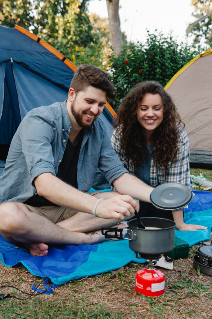 A couple cooking in a camp site